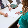 pregnant woman completing paperwork for FMLA