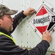 Man flipping placard on trailer to dangerous placard