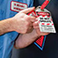 Man applying lock and danger do not operate tag