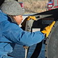 Woman inspcetion tires on semi trailer