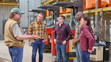 Man speaking with group of employees in warehouse