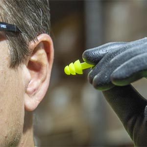 ANSI compliant ear plugs being placed in ear.