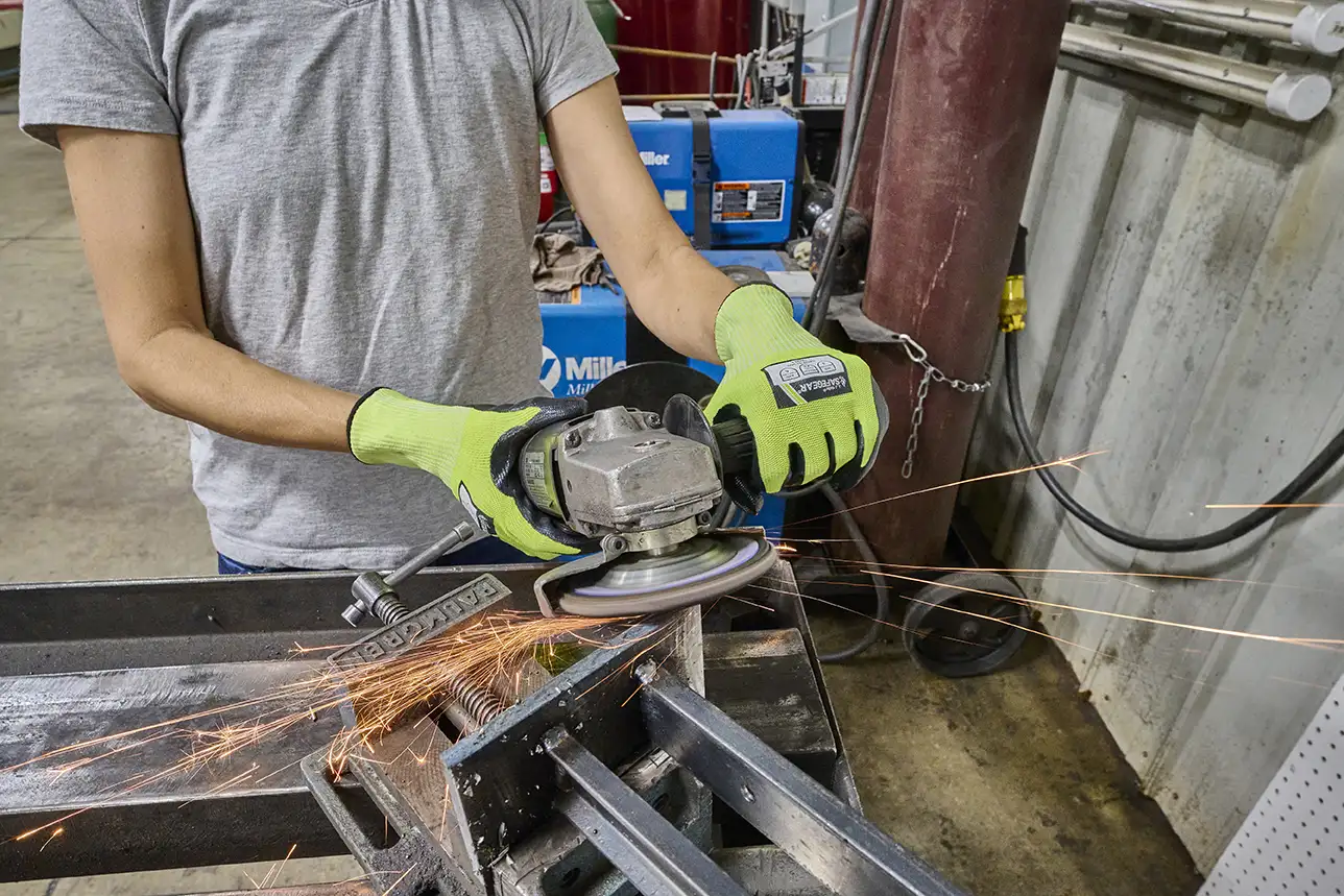 A worker using and angle grinder wearing proper PPE